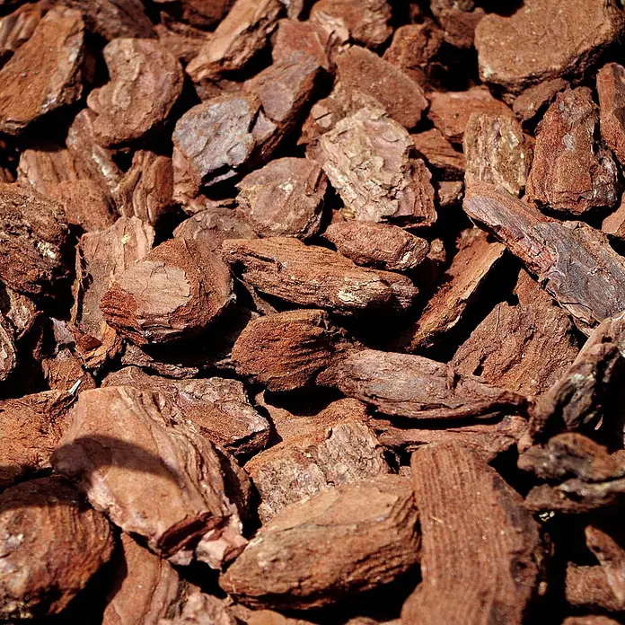 Rindenmulch Pinie Deko Plus 60-100 mm 60l x 12 Sack 720l 12er Palette -  - Nahaufnahme von rötlich-braunem Rindenmulch in verschiedenen Größen und Texturen für Garten- und Landschaftsbau.
