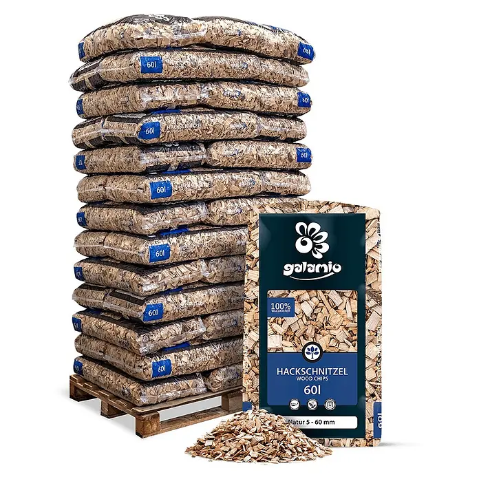 Hackschnitzel Holzdekor Natur 5-60 mm 60l x 39 Sack 2340l Palette -  - Ein Stapel Plastiksäcke gefüllt mit natürlichen Holzspänen auf einer Holzpalette, mit einem einzelnen Sack und losen Spänen im Vordergrund.