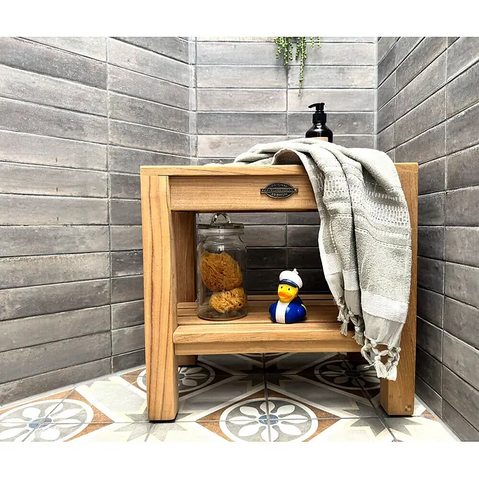 Duschhocker Holz Stella als edler Teak Duschstuhl mit Anti-Rutsch-Füßen -  - Ein kompakter, zweistufiger Teakholz-Duschhocker mit Handtuch, Schwämmen und Quietscheente in einer gefliesten Badezimmerecke.
