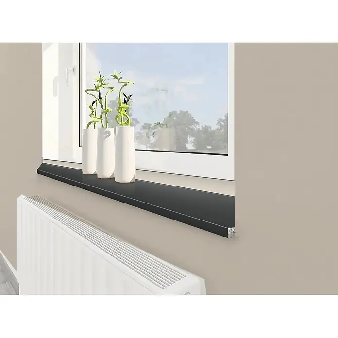 Fensterbank Profil 207 - L x B x S: 410 cm x 40 cm x 20 mm, Anthrazit, Holz, Systemattribut Herstellerwert Spanplatte P3 nach EN 312 / Spanplatte P5 - Elegante schwarze Fensterbank mit drei dekorativen Vasen und Glücksbambus, über einem weißen Heizkörper.