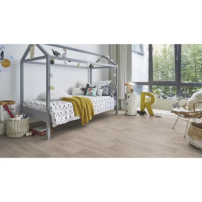 PVC-Boden Meterware Vinylboden 2m Diele Eiche grau -  - Ein gemütliches Kinderzimmer mit grauem Hausbett, verspielter Bettwäsche, hellem Holzboden und großem Fenster mit Blick auf Bäume.