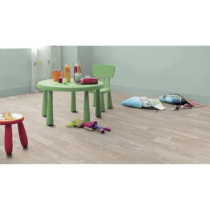 PVC-Boden Meterware Vinylboden 4m Diele Eiche hell-grau -  - Heller Laminatboden in Holzoptik in einem Kinderspielbereich mit grünem Tisch und Spielzeug.