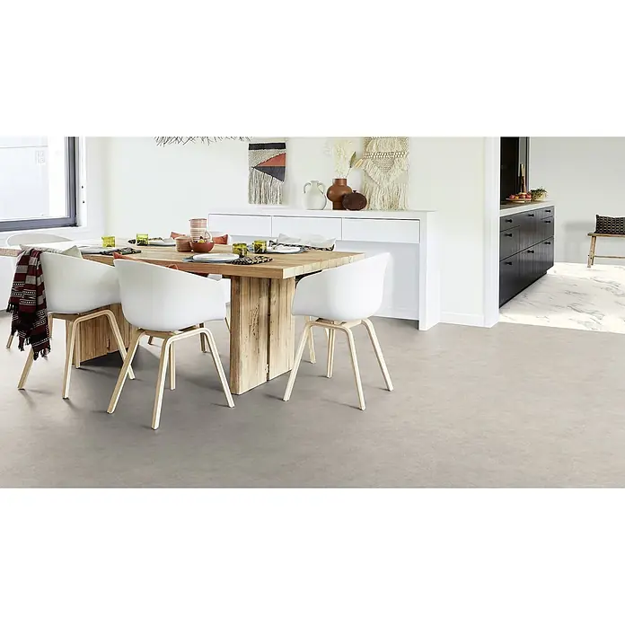PVC-Boden Meterware Vinylboden 4m Betongrau -  - Helles graues Bodencovering in einem modernen Esszimmer mit Holztisch und weißen Stühlen.
