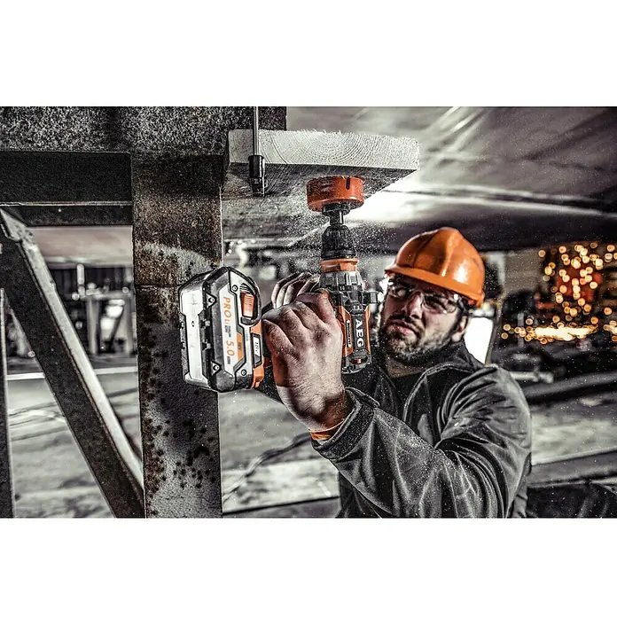 AEG Pro 18V Akku-Schlagbohrschrauber BSB 18 CBL - 18 V, Ohne Akku, 60 Nm - Ein Handwerker mit Schutzbrille bohrt mit einem AEG Akku-Bohrschrauber ein Loch in ein Holzbrett.