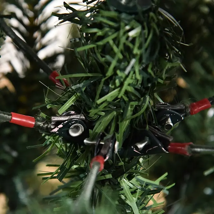 HOMCOM-Christbaum-Ø105 x 150H cm-Grün -  - Detailaufnahme künstlicher Kiefernnadeln mit integrierten schwarzen Stromverbindern und roten Kabelkappen eines beleuchteten Weihnachtsbaums.