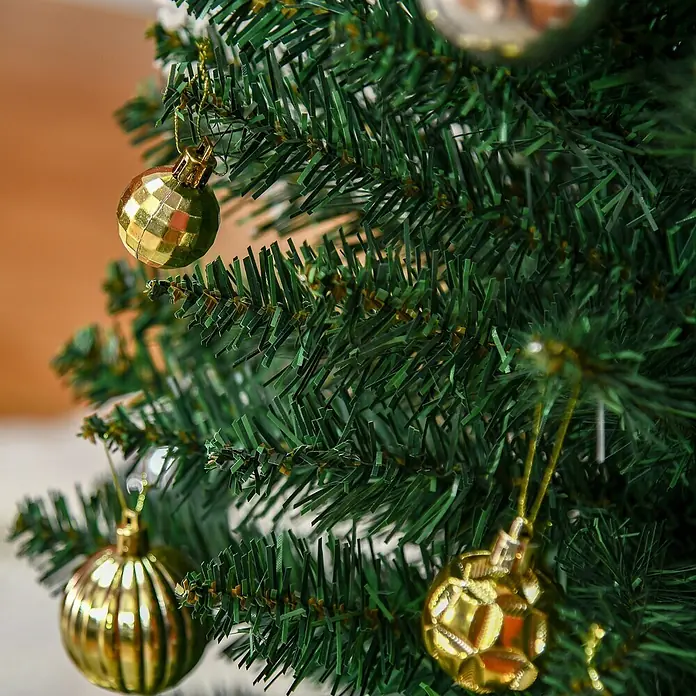 HOMCOM-Weihnachtsbaum-Ø55 x 180H cm-Grün -  - Nahaufnahme von künstlichen grünen Weihnachtsbaumzweigen, geschmückt mit verschiedenen glänzenden goldenen Kugeln.