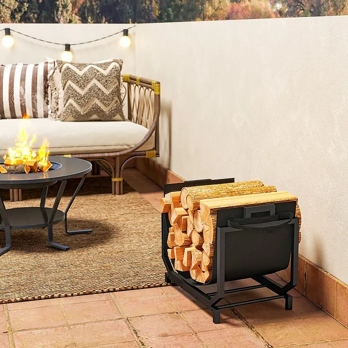 Outsunny- Kaminholzregal-53 x 33 x 43 cm -  - Schwarzes Metall-Brennholzregal, gefüllt mit Holzscheiten, auf einer Terrasse neben Feuerstelle und Sofa.