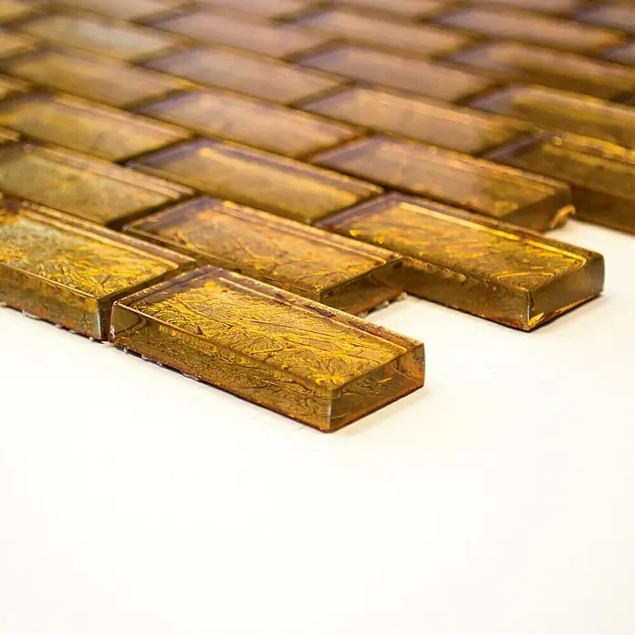 Mosaikfliese Brick Crystal Uni XCM 8GO35 - 30 x 30 cm, Gold, Glänzend - Nahaufnahme von rechteckigen, goldfarbenen Glasmosaikfliesen mit reflektierender Oberfläche, ideal für Wandverkleidungen.
