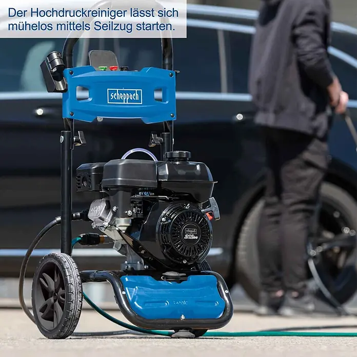 Scheppach Hochdruckreiniger HCP5000 - 4,3 kW, Max. Druck: 241 bar, Fördermenge: 590 l/h - Blauer und schwarzer Scheppach Hochdruckreiniger mit Motor und Rädern, draußen gezeigt. Lässt sich mühelos per Seilzug starten.