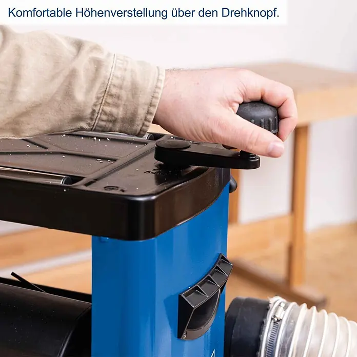 Scheppach Dickenhobelmaschine PLM1800 - 1.500 W, 8.500 U/min, Max. Spanabnahme Dickenhobel: 2,8 mm - Eine Hand betätigt einen schwarzen Drehknopf zur komfortablen Höhenverstellung an einer blauen Holzbearbeitungsmaschine.