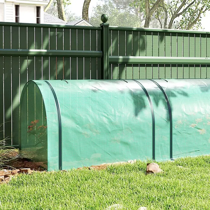 Outsunny-Gewächshaus-350L x 100B x 80H cm -  - Grünes, bogenförmiges Folientunnel-Gewächshaus mit Reißverschluss, schützt Pflanzen im Garten neben einem Zaun.
