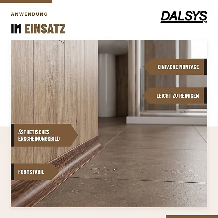 Dalsys Weichsockelleiste Selbstklebend 15m Grau Fußbodenleiste -  - Dunkelbraune Holzoptik-Sockelleiste, installiert in einem Raum mit Holzwänden und Fliesenboden, mit Wassertropfen auf dem Boden.
