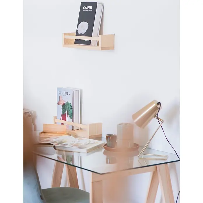 Astigarraga Encimera de cristal con caballetes - Vidrio templado, Pino, 120 x 60 cm - Oficina en casa minimalista con dos estantes de madera natural para libros y un escritorio de cristal. Una lámpara dorada y libros adornan el espacio de trabajo.