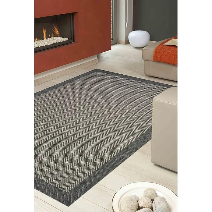 Dekoria Teppich Breeze cliff grey 200x290cm -  - Grauer Teppich mit Fischgrätmuster und dunklem Rand auf hellem Holzfußboden im gemütlichen Wohnzimmer.