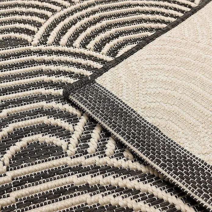 Dekoria Teppich Jersey Home beige/black 120x170cm -  - Gewebter Teppich mit schwarz-beigen geometrischen Mustern. Eine umgeschlagene Ecke zeigt die unifarbene Rückseite und detaillierte Textur.