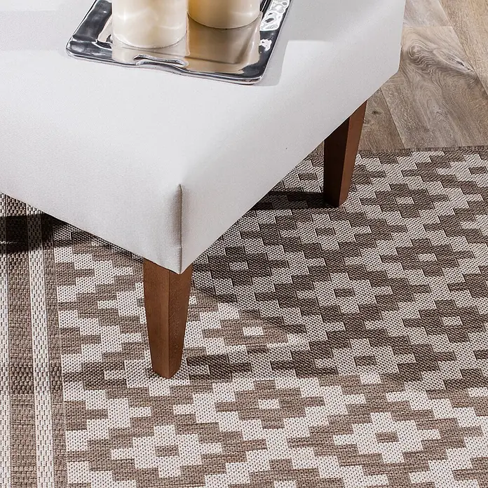 Dekoria Teppich Modern Rhombs mink/beige 120x170cm -  - Weiß gepolsterter Hocker mit Holzbeinen, darauf ein Tablett mit Kerzen, auf einem gemusterten braun-weißen Teppich.