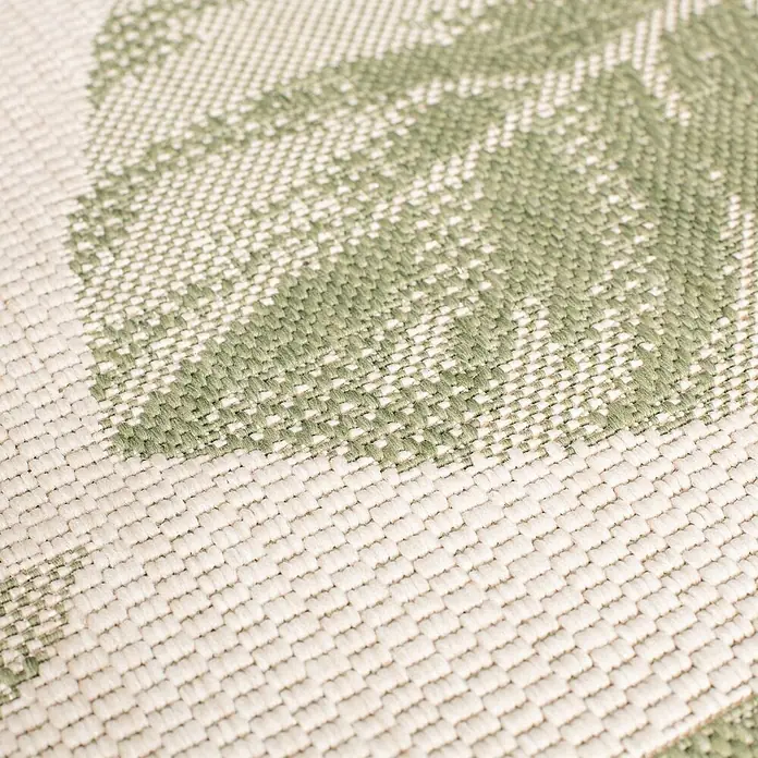 Dekoria Teppich Cottage beige/jungle green 120x170cm -  - Nahaufnahme eines gewebten Textils mit hellgrünem Blattmuster auf cremefarbenem Grund.