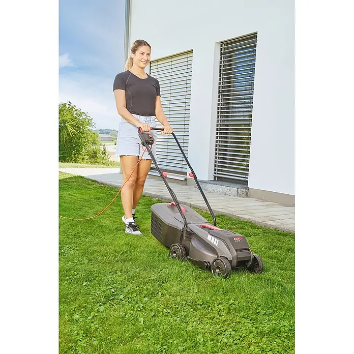 AL-KO Elektro-Rasenmäher 3.37 E - 1.200 W, Schnittbreite: 33 mm, Max. Flächenempfehlung: 250 m² - Eine Frau mäht Gras mit einem grau-schwarzen Rasenmäher mit roten Akzenten.