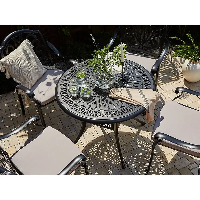 Runder Tisch ANCONA in Schwarz/Beige - (W) 90 x (H) 72 x - L - Dunkelgraues Bistrot-Set aus Aluminiumguss mit hellen Kissen auf gepflasterter Terrasse.