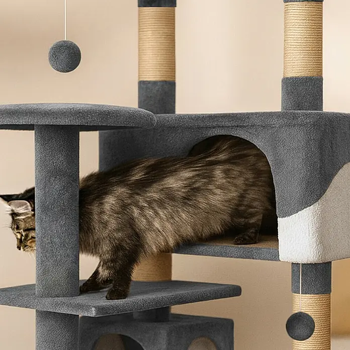 belviona Kratzbaum 130 cm mit Höhlen, Treppe & Spielbällen, grau/weiß -  - Mehrstufiger Katzenbaum in Grau und Weiß mit Sisalkratzpfosten; eine Katze betritt eine Höhle.