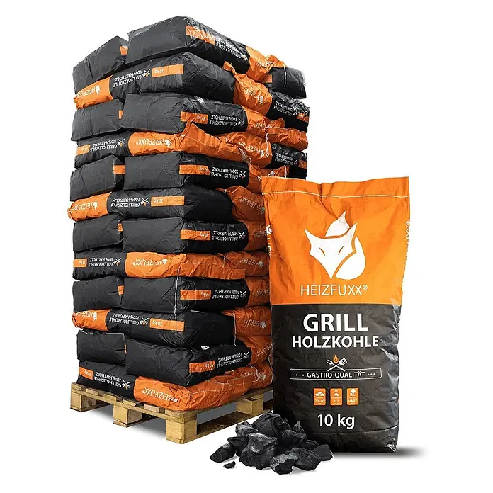 Grillholzkohle in Gastro-Qualität 10kg x 36 Sack 360kg Palette -  - Großer Stapel schwarzer und oranger 10kg HEIZFUXX Hartholz-Grillkohlesäcke auf Palette, dazu loser Kohle im Vordergrund.