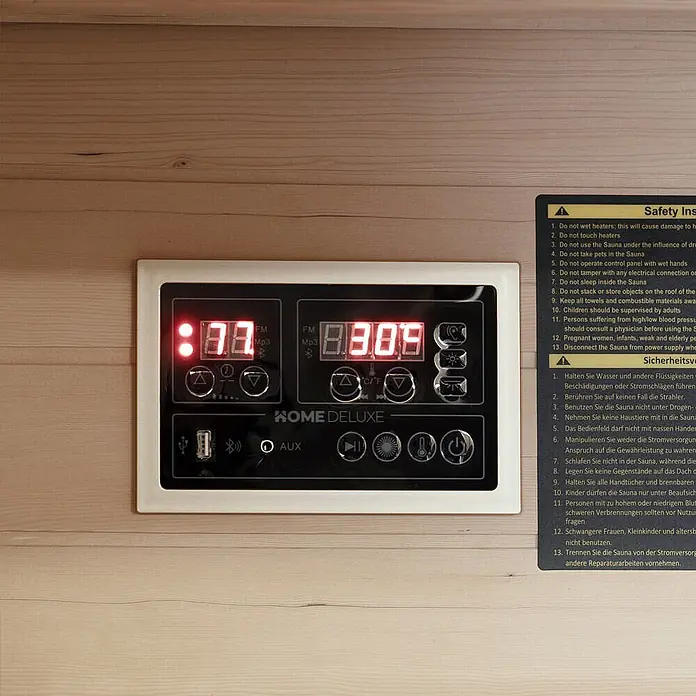 Home Deluxe Infrarotkabine NERO M Schwarz -  - Schwarzes Saunasteuerpanel mit roten LED-Anzeigen für Zeit und Temperatur, in Holzwand eingebettet. Es hat Tasten für FM/MP3, AUX und Einstellungen.