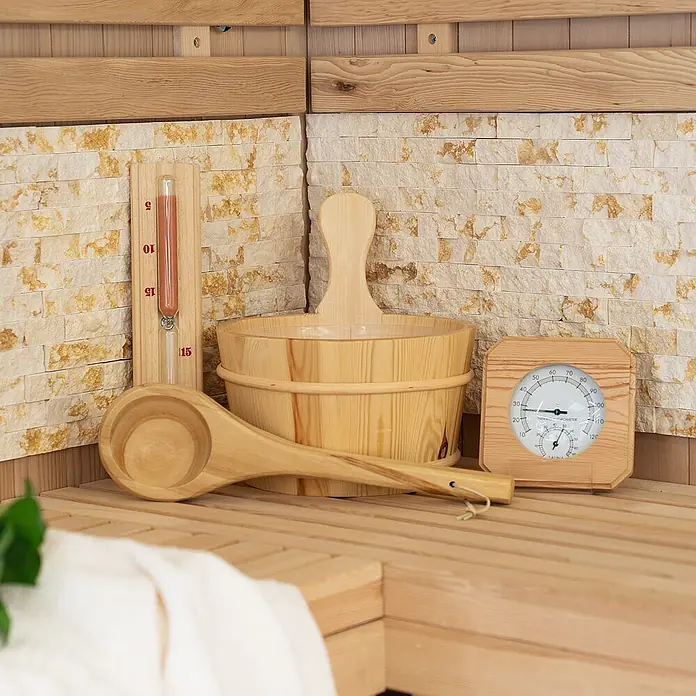 Home Deluxe Sauna-Zubehör Q PREMO 5 -  - Saunazubehör aus Holz: Eimer, Kelle, Sanduhr und Thermometer, auf Saunabänken arrangiert.