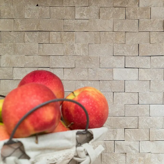 Mosaikfliese Brick Splitface X3D 40060 - 30,5 x 29 cm, Weiß, Matt - Nahaufnahme eines Korbs voller roter Äpfel vor einer Steinmauer, die die natürliche Schönheit der Früchte und die Textur des Hintergrunds hervorhebt.