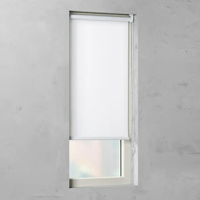 Rollo Basic - B x H: 80 x 175 cm, Weiß, Uni, Tageslichtdurchlässig - Das Bild zeigt eine weiße Rollgardine vor einem Fenster in einem Raum mit grauen Wänden. Die Rollgardine ist teilweise heruntergezogen.