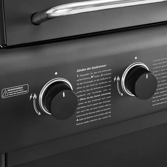 TAINO COMPACT 3+0 Gasgrill Platzsparend Schwarz -  - Detailaufnahme eines schwarzen Gasgrill-Bedienfelds mit zwei Drehknöpfen, Zündsymbolen und Sicherheitshinweisen.