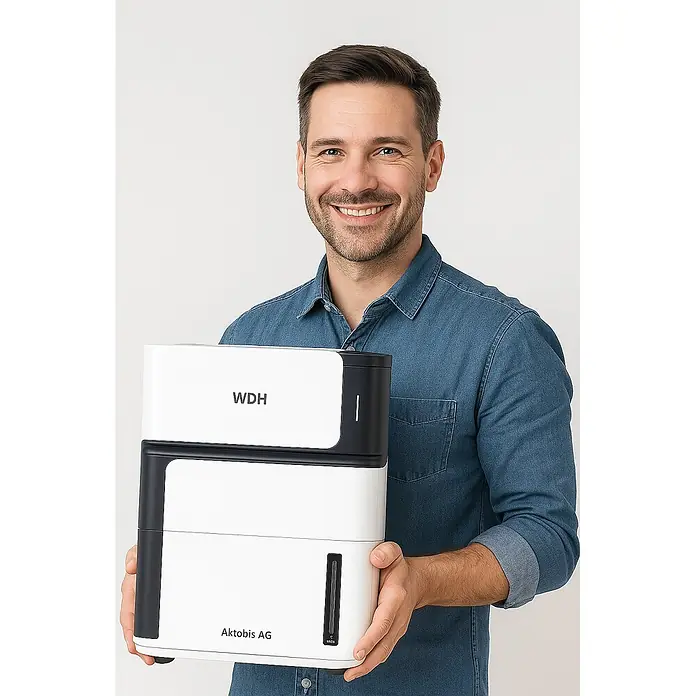 WDH Luftentfeuchter WDH-106LE - für 15m² - 8 Liter/Tag -  - Mann lächelt, hält ein weiß-schwarzes WDH Aktobis AG Gerät.