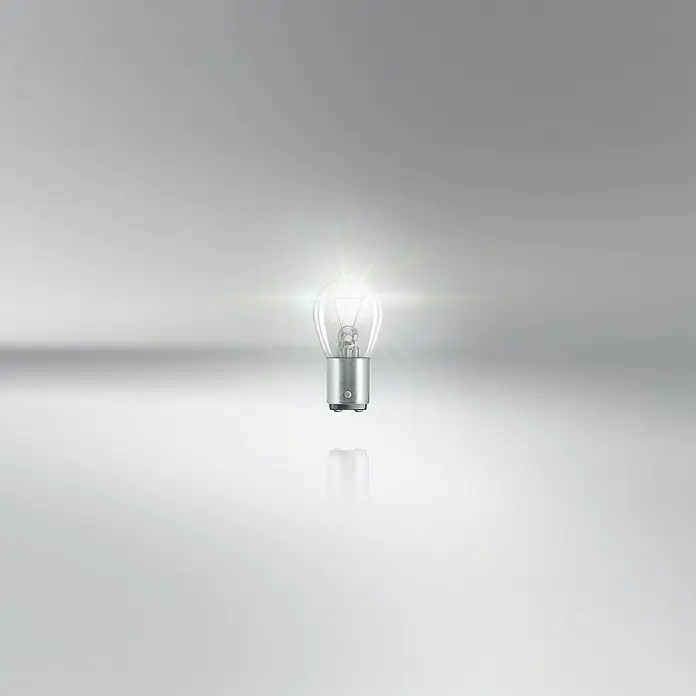 Osram Brems- & Schlusslichtleuchte Ultra Life - P21/5W, 2 Stk. - Nahaufnahme einer leuchtenden, transparenten Glühbirne mit Metallsockel auf einem neutralen Hintergrund.