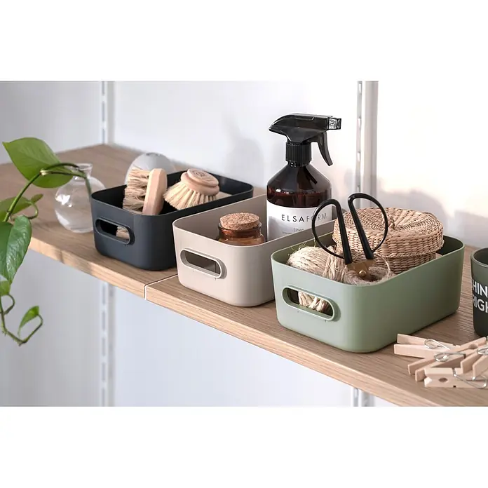 SmartStore Aufbewahrungsbox Comfort M - L x B x H: 29,5 x 19,5 x 12 cm, Kunststoff, Moss, 5,3 l - Drei Kunststoff-Aufbewahrungskörbe in Dunkelgrau, Beige und Grün auf einem Holzregal zur Organisation von Haushaltsartikeln.