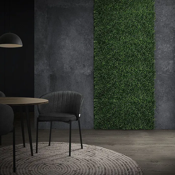 Künstliche Pflanzenwand Kunstpflanzen Wand Innen Aussen Classic Buxus -  - Grünes Kunstheckenpaneel an einer dunklen Wand, das einen Essbereich mit naturgetreuem Blattwerk aufwertet.