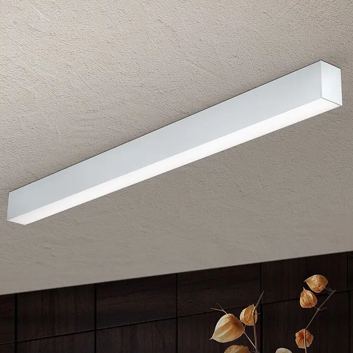 Orion Leuchten Pendelleuchte Balken Silber Kaltweiß 30 W -  - Eine weiße, rechteckige LED-Deckenleuchte ist an einer strukturierten Decke montiert und spendet helles Licht.