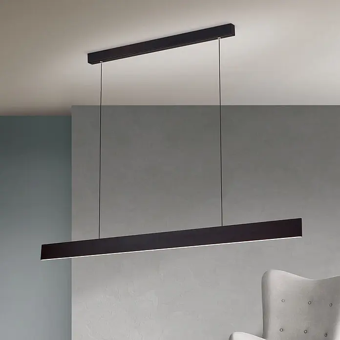 Orion Leuchten Pendlleuchte Gideon Schwarz -  - Elegante schwarze lineare LED-Pendelleuchte hängt von der Decke und beleuchtet einen modernen Raum mit einem grauen Sessel.