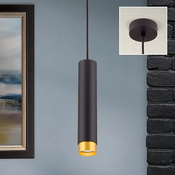 Orion Leuchten Pendelleuchte Martini H 30 cm -  - Schwarze zylindrische Pendelleuchte mit goldenem Inneren, hängt von der Decke in einem Raum mit Bild und Ziegelwand.