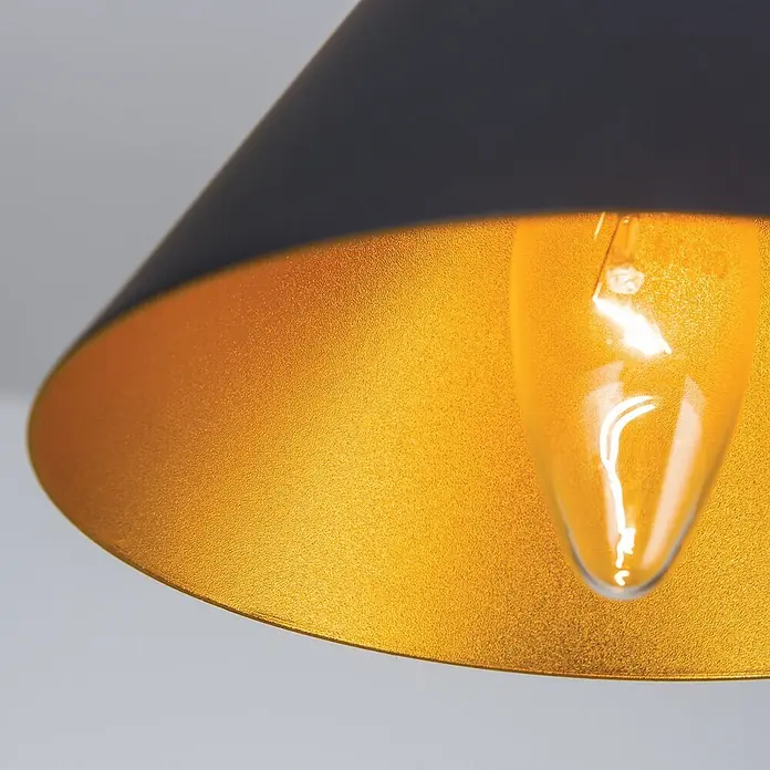 Orion Leuchten Pendelleuchte Gunda Ø 16.5 cm -  - Nahaufnahme einer Lampe mit schwarzer Außenseite und texturierter goldener Innenseite, mit einer leuchtenden Klarglasbirne.