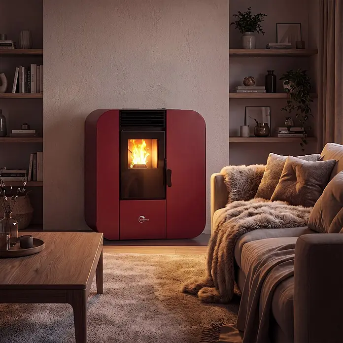 Pelletofen Slim Astral 9,4 kW Bordeaux Sannover -  - Roter Pelletofen mit geschwungenem Design, zeigt ein warmes Feuer und beheizt ein gemütliches Wohnzimmer.