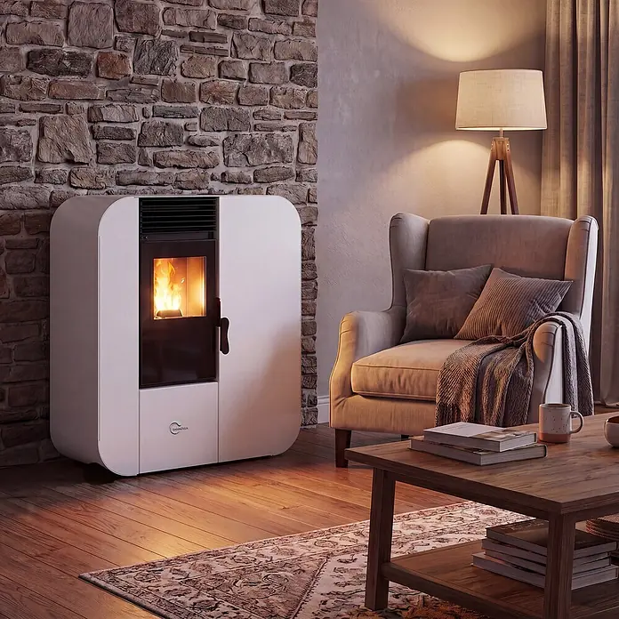 Pelletofen Slim Astral 13,8 kW Weiß Sannover -  - Moderner weißer Pelletofen mit sichtbarer Flamme, der ein gemütliches Wohnzimmer mit Steinwand und Sessel wärmt.