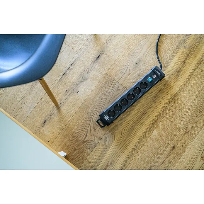 Brennenstuhl Premium-Line Steckdosenleiste - 6-fach, Schwarz, Kabellänge: 3 m, Mit Schalter - Schwarze 8-fach Steckdosenleiste aus Kunststoff mit grün beleuchtetem Schalter auf hellem Holzboden.