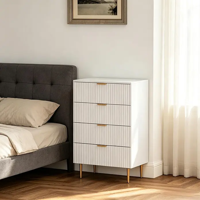 SONNENH Kommode 60 x 40 x 96 cm, Weiß -  - Weiße geriffelte Kommode mit goldenen Griffen und Beinen, neben einem Bett im Schlafzimmer.