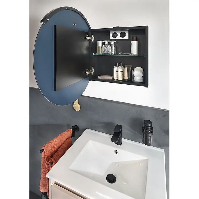 Riva Sabbia Badmöbel-Set - Gesamtbreite Badmöbel: 61,5 cm, Kaschmir/Schwarz, Matt - Offener schwarzer Badspiegelschrank mit rundem blauem Spiegel, der Toilettenartikel über einem Waschbecken zeigt.