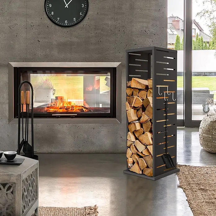 ML-Design Kaminholzregal Metall 37,5x37,5x112 cm Anthrazit Gitter-Motiv -  - Hoher, dunkelgrauer Metall-Brennholzständer mit Lamellenseiten und Haken für Werkzeuge, gefüllt mit Holzscheiten neben einem modernen Kamin.