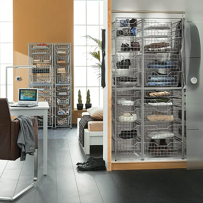 Regalux Clever Cesta - 45 x 28 x 7 cm, Metal - La imagen muestra un sistema de estanterías con cestas de alambre para el almacenamiento, perfecto para dormitorios o vestidores. ¡Práctico y bien organizado!