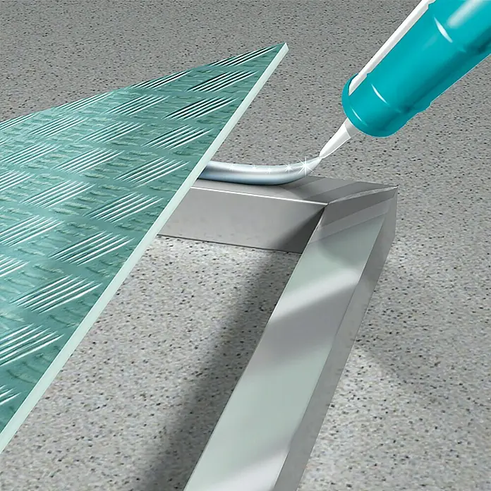 MEM Montagekleber ALLGROUND 3in1 - Metall, 305 g - Das Bild zeigt eine Kartusche mit Dichtungsmasse, die zum Abdichten einer Metallabdeckung auf einer Betonoberfläche verwendet wird.