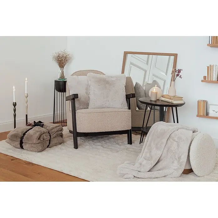 Dekokissen & Decken-Set Aimee - 2 -tlg., Grau/Blau - Gemütliches Wohnzimmer mit hellem Kunstfellteppich, Decken und Kissen auf einem Sessel, das eine warme Atmosphäre schafft.