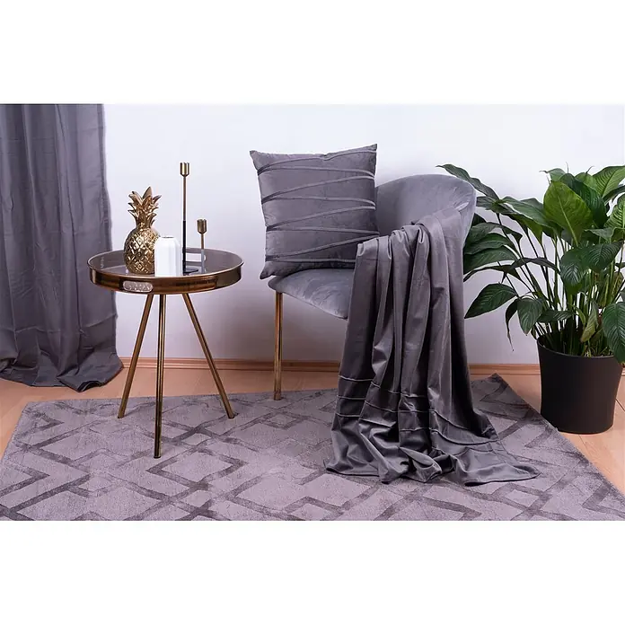 Dekokissen & Decken-Set Paulina - 2 -tlg., Graphit - Graues Samtkissen mit strukturierten Streifen und passende Samtdecke über einem grauen Stuhl in gemütlicher Wohnzimmerumgebung.