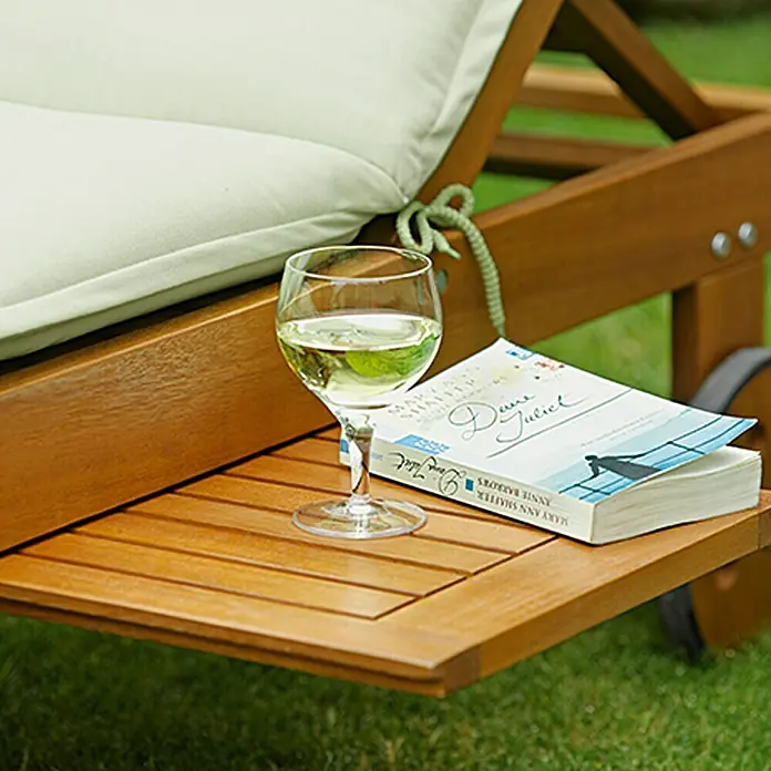 Sunfun Diana Tumbona de jardín - 65 x 190 x 33 cm, Marrón natural, Madera, Barra antivuelco - Tarde relajante: una copa de vino y el libro "Dear Juliet" sobre una mesa auxiliar de madera de una tumbona.