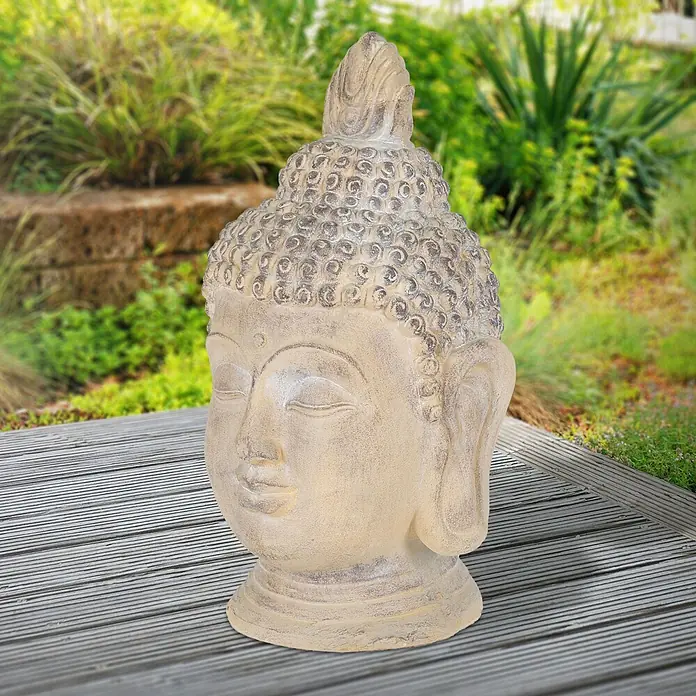 Buddha Kopf 45 x 39 x 78 cm, Beige-Grau -  - Verwitterte hellgraue Buddha-Kopf-Statue mit gelassenem Ausdruck, draußen auf Holzterrasse.